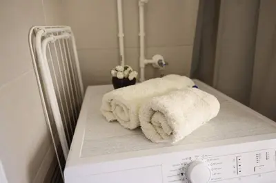 a stack of towels sitting on top of a washing machine at Viki Apartment CENTAR in Niš