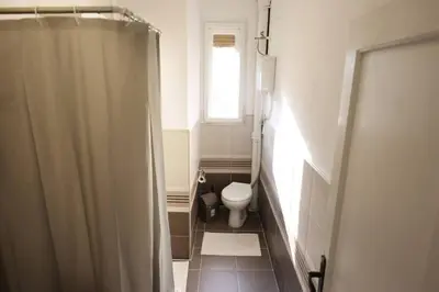 a small bathroom with a toilet and a window at Viki Apartment CENTAR in Niš