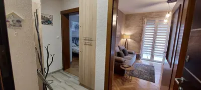 a living room with a couch and a room with a window at Apartman Lora in Vrnjci