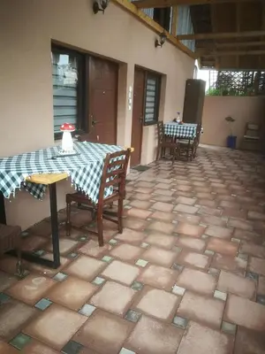 a patio with a table and chairs on a tiled floor at Odmaralište Vlaško ždrelo in Pirot