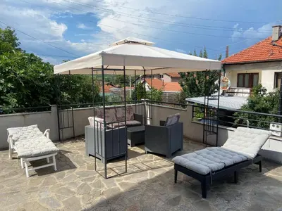 a patio with an umbrella and two chairs and a table at Apartman Boskovic in Soko Banja