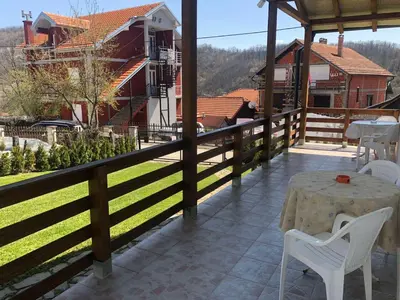 a patio with a table and chairs on a balcony at Vila Zdravković Prolom Banja in Prolomska Banja