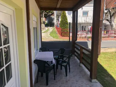 a patio with a table and chairs on a porch at Vila Zdravković Prolom Banja in Prolomska Banja