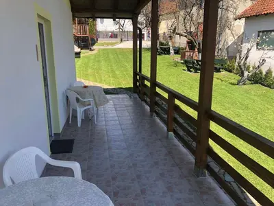 a patio with a table and chairs on a porch at Vila Zdravković Prolom Banja in Prolomska Banja