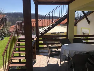 a balcony with a table and chairs and a staircase at Vila Zdravković Prolom Banja in Prolomska Banja