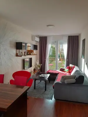 a living room with a couch and red chairs at Una in Vrnjačka Banja