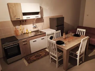 a small kitchen with a table and a stove and refrigerator at Apartman Todorovic in Jagodina