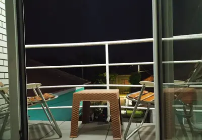 a chair sitting on a balcony with a view of a pool at Apartman Todorovic in Jagodina