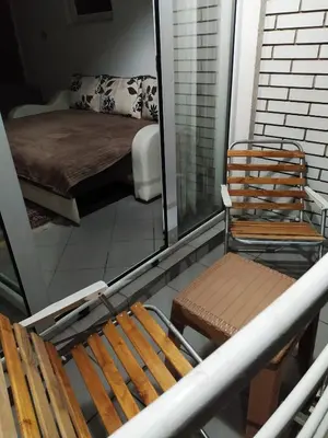 a balcony with two chairs and a bed and a mirror at Apartman Todorovic in Jagodina
