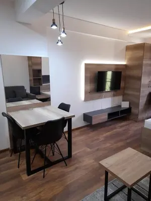 a living room with a dining table and a tv at Apartmani President Kop in Kopaonik