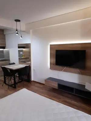 a living room with a large television and a table with chairs at Apartmani President Kop in Kopaonik