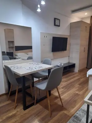 a dining room with a table and chairs and a bed at Apartmani President Kop in Kopaonik