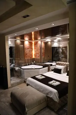 a bedroom with a large bed and a bath tub at Design Apartment GRAND SPA LUX 4 STAR 