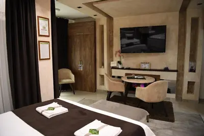 a hotel room with a bed and a table and a television at Design Apartment GRAND SPA LUX 4 STAR 