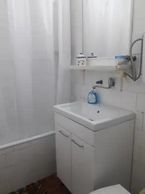 a white bathroom with a sink and a mirror at Kutak- stan na dan in Paraćin
