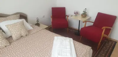 a bedroom with a bed and two chairs at Kutak- stan na dan in Paraćin