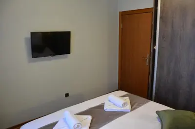 a bedroom with a bed with a television on the wall at MONA RELAX in Vrnjačka Banja