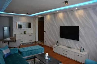 a living room with a couch and a television on a wall at MONA RELAX in Vrnjačka Banja