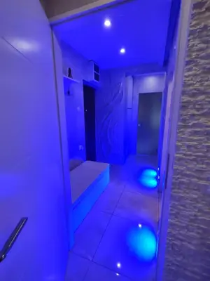 a bathroom with blue lights in a room at Apartman Cristallino in Niš