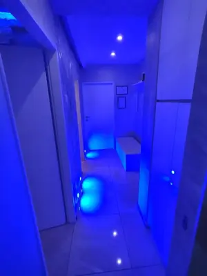 a dark room with a hallway with blue lights at Apartman Cristallino in Niš