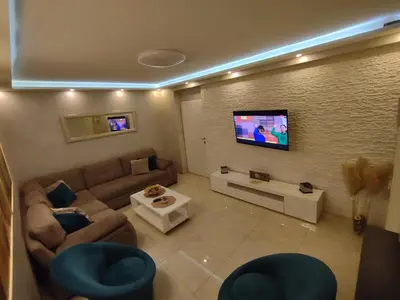 a living room with a couch and a flat screen tv at Apartman Cristallino in Niš