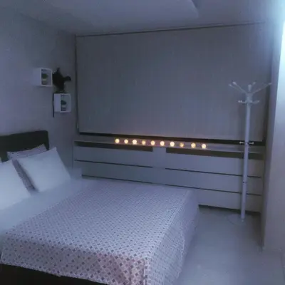 a bedroom with a bed and a window with a cross on it at Apartman Cristallino in Niš