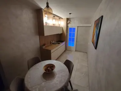 a kitchen and a table in a small room at Apartman Cristallino in Niš