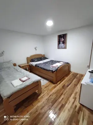 two beds in a room with wooden floors at Vila Vera Borsko Jezero in Bor