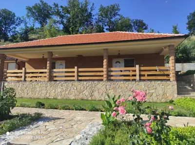 a house with a fence and a stone wall at Vila Vera Borsko Jezero in Bor