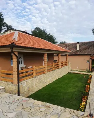 a house with a wooden fence and a yard at Vila Vera Borsko Jezero in Bor