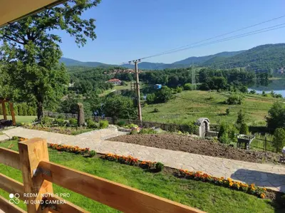a bench in a garden with a view of a lake at Vila Vera Borsko Jezero in Bor