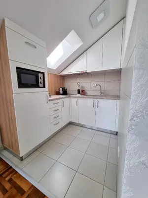 a white kitchen with a sink and a microwave at AS Delux Apartmani in Soko Banja