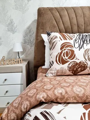 a bed with a brown and white comforter and pillows at AS Delux Apartmani in Soko Banja