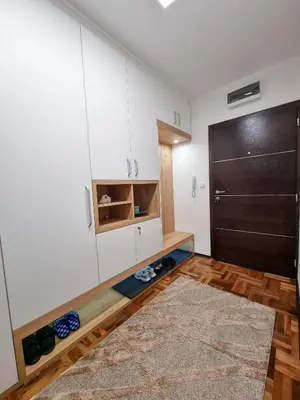 a kitchen with white cabinets and a black refrigerator at AS Delux Apartmani in Soko Banja