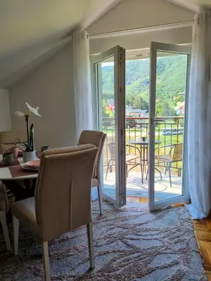 a living room with a door open to a balcony at AS Delux Apartmani in Soko Banja
