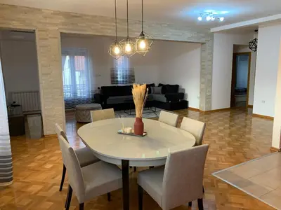a dining room table and chairs in a living room at Apartman Gogić in Vrnjačka Banja