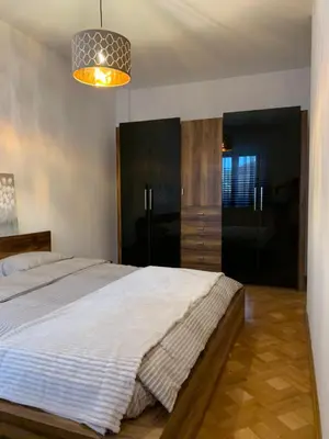 a bedroom with a large bed and a chandelier at Apartman Gogić in Vrnjačka Banja