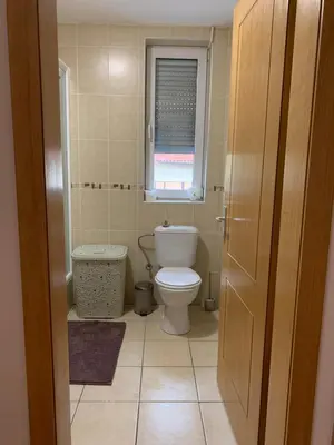 a small bathroom with a toilet and a window at Apartman Gogić in Vrnjačka Banja