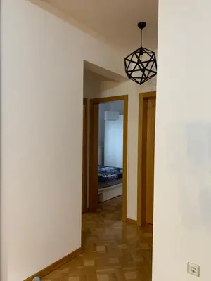 a hallway with a room with a bed and a chandelier at Apartman Gogić in Vrnjačka Banja