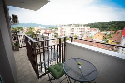 a balcony with two chairs and a table at Apartman NINA in Vrnjačka Banja