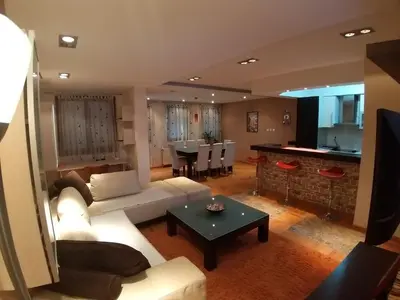 a living room with a couch and a table at Brown Apartment - Niš Center in Niš