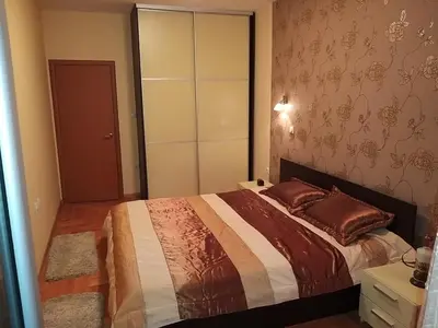 a bedroom with a bed and a dresser and a closet at Brown Apartment - Niš Center in Niš