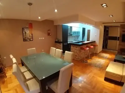 a kitchen and dining room with a table and chairs at Brown Apartment - Niš Center in Niš