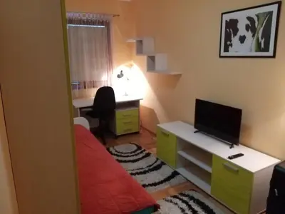 a small room with a desk with a monitor and a computer at Brown Apartment - Niš Center in Niš