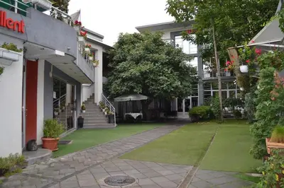 a building with a green lawn in front of it at LIRA EXCELLENT NIS in Niš