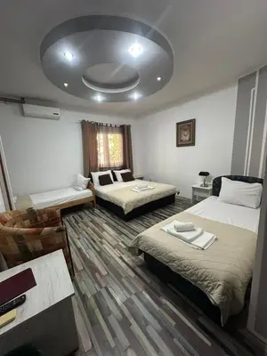 a hotel room with two beds and a couch at LIRA EXCELLENT NIS in Niš