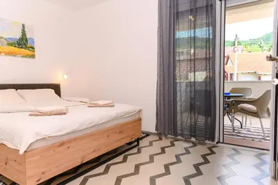 a bedroom with a bed and a balcony at Apartman N&P in Soko Banja