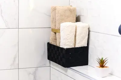 a stack of towels in a bathroom with white tiles at Apartman N&P in Soko Banja