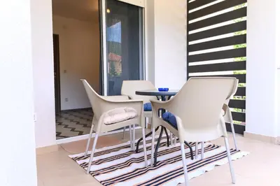 a dining room with white chairs and a table at Apartman N&P in Soko Banja