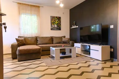 a living room with a couch and a flat screen tv at Apartman N&P in Soko Banja